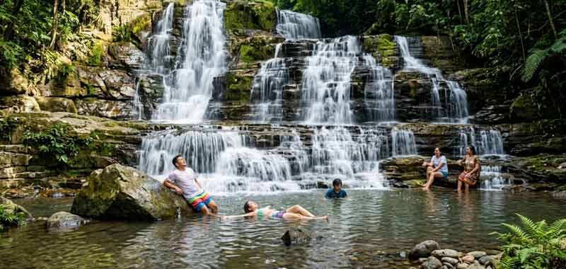 Visitors swimming at the natural pool of Merloquet Falls